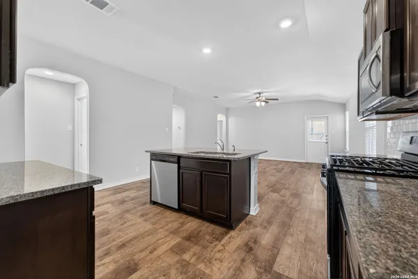 a kitchen with stainless steel appliances granite countertop a stove a sink and a refrigerator