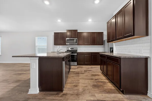 a kitchen with stainless steel appliances granite countertop a stove a sink and a refrigerator