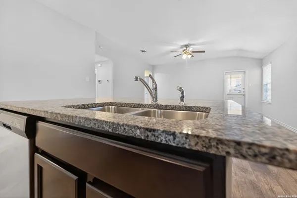 a kitchen with granite countertop a sink cabinets and stainless steel appliances