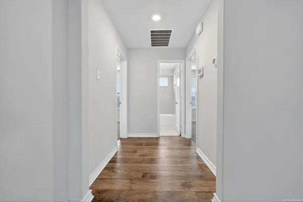 a view of a hallway with wooden floor