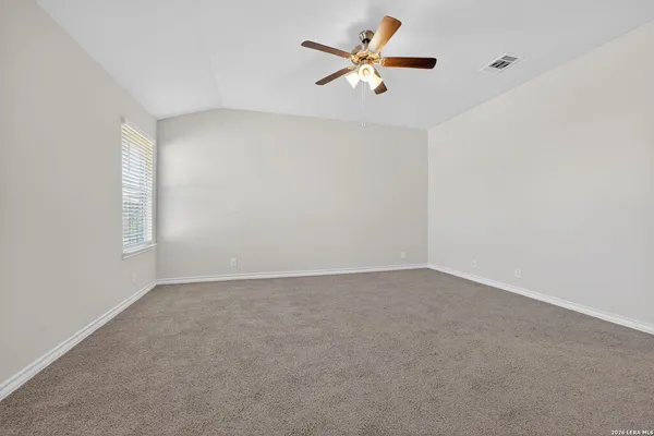 an empty room with a window and a fan