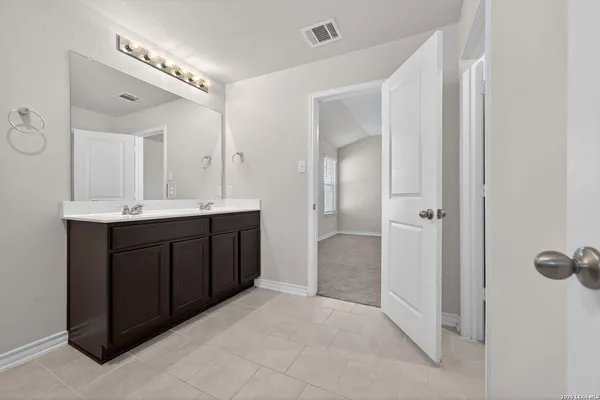 a bathroom with a double vanity sink a mirror and a shower