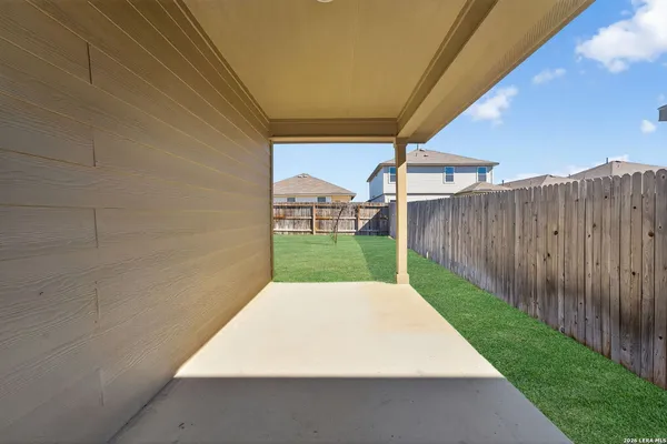 a view of a backyard with wooden fence