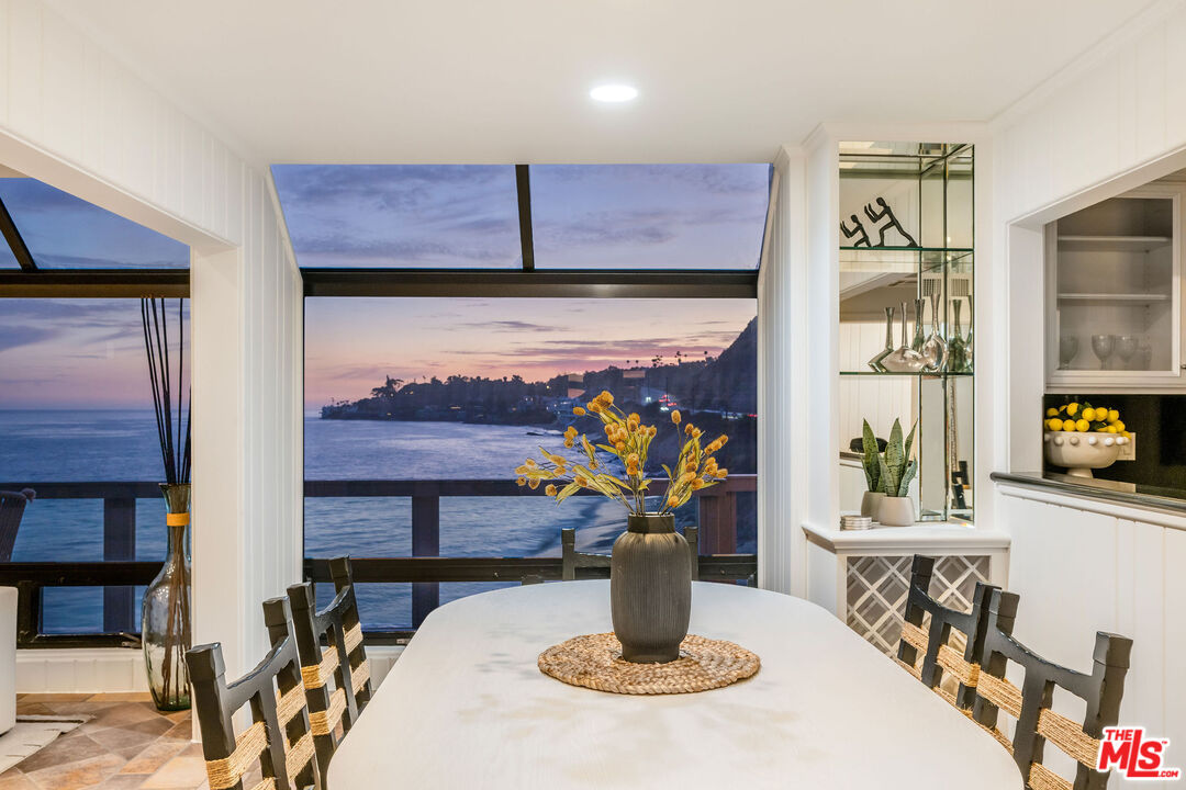 26174 Pacific Coast Highway Malibu, CA 90265 - Photo 21 of 33 a view of a dining room with furniture and a potted plant