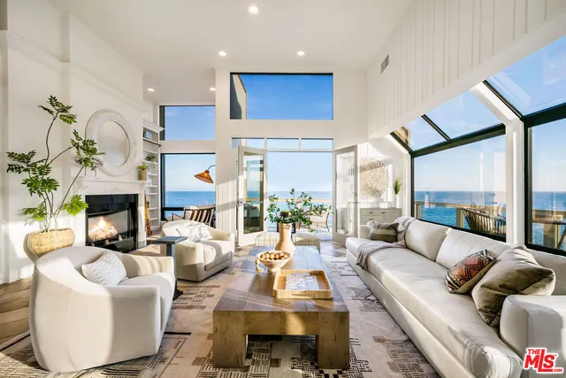 a living room with fireplace furniture and a large window