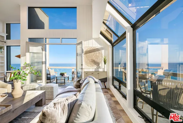 a living room with furniture and a floor to ceiling window