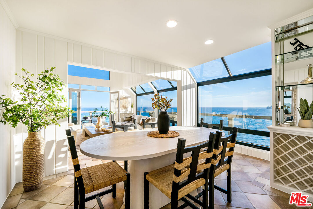 26174 Pacific Coast Highway Malibu, CA 90265 - Photo 7 of 33 a view of a dining room and livingroom with furniture wooden floor a rug a potted plant and a chandelier