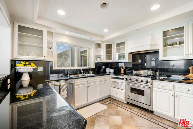 a kitchen with a stove sink and cabinets