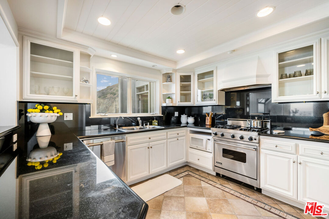26174 Pacific Coast Highway Malibu, CA 90265 - Photo 10 of 33 a kitchen with a stove sink and cabinets