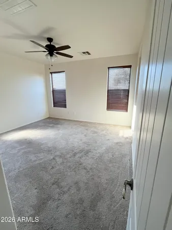 an empty room with windows and fan
