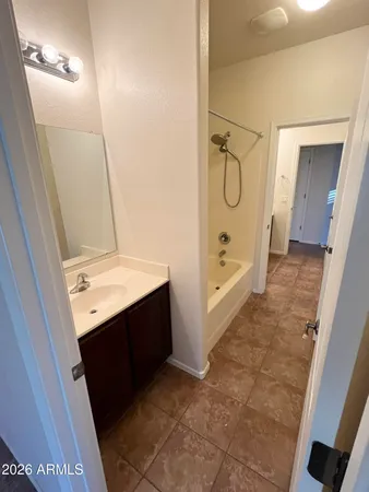 a bathroom with a double vanity sink and mirror with bathtub