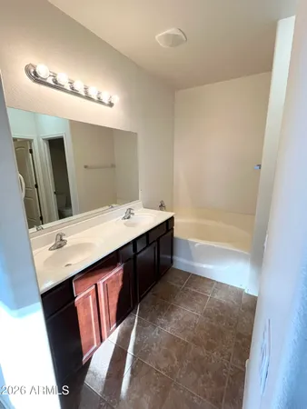 a bathroom with a tub sink and mirror