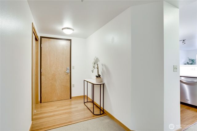 a view of a hallway with a dining table chair and a refrigerator