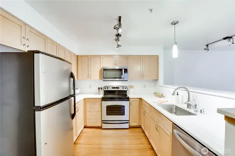 a kitchen with stainless steel appliances a refrigerator sink and microwave