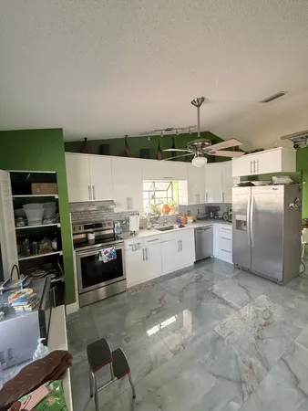 a kitchen with granite countertop a refrigerator stove top oven and sink