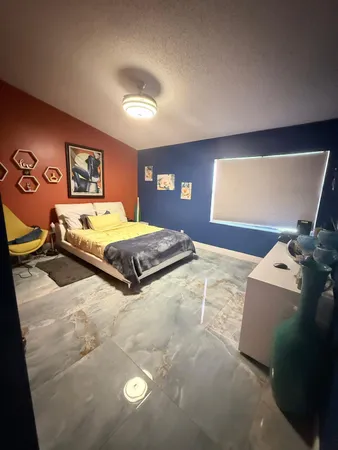 a spacious bedroom with a bed and a flat screen tv