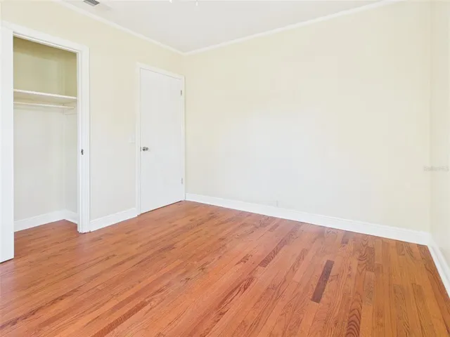 a view of empty room with wooden floor
