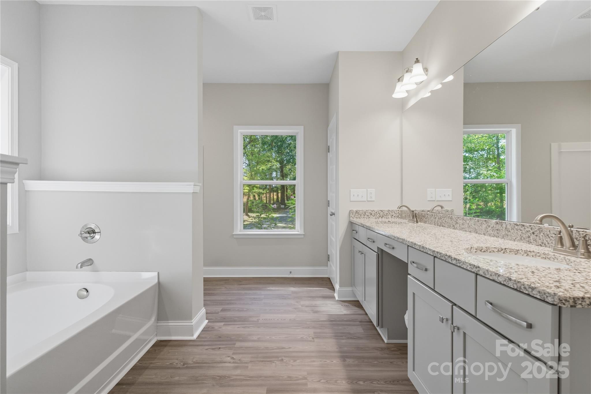 1830 Austin Chaney Road Wingate, NC 28174 - Photo 17 of 39 a spacious bathroom with a granite countertop tub a double vanity sink a window and a mirror