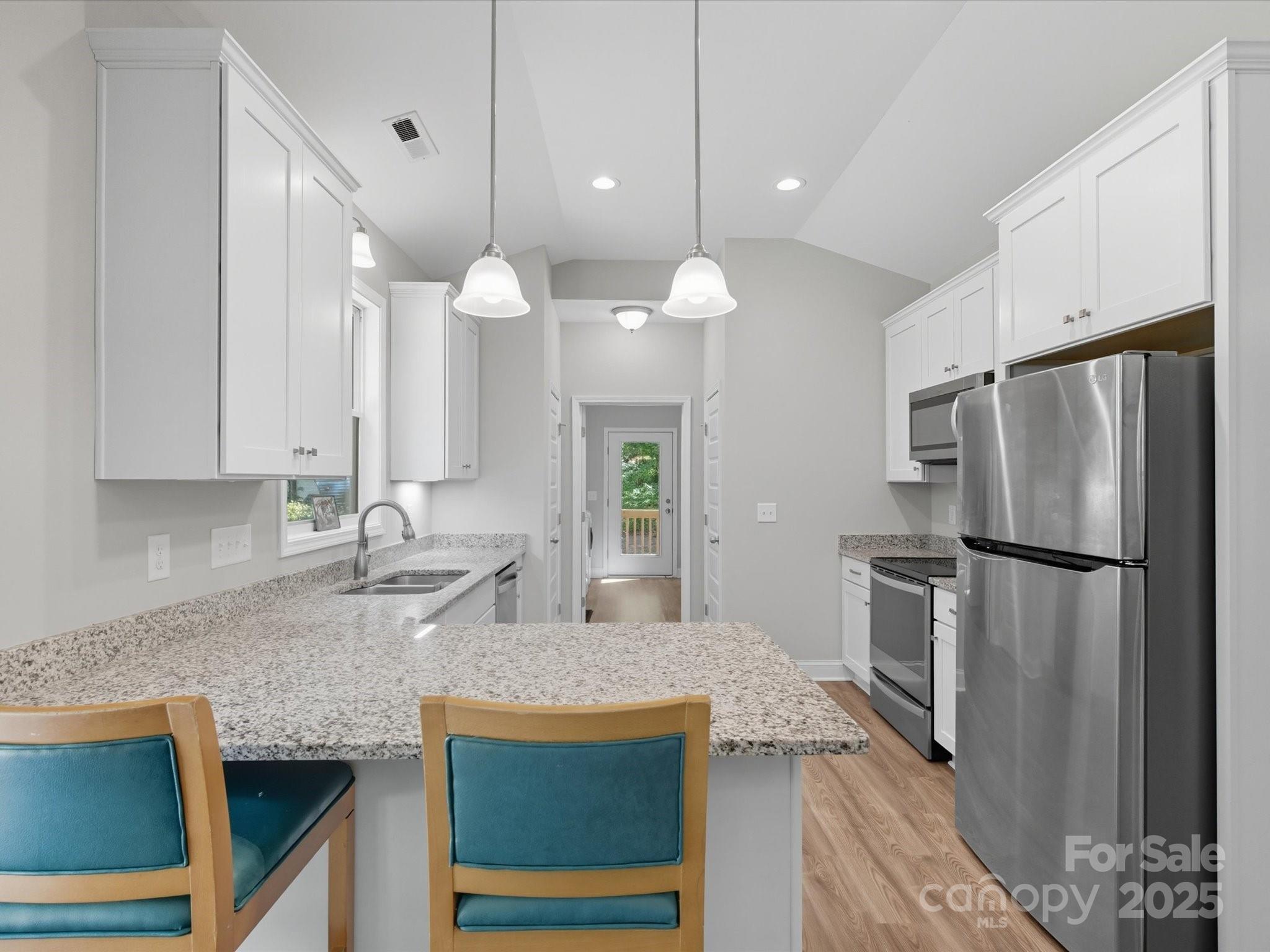 1830 Austin Chaney Road Wingate, NC 28174 - Photo 10 of 39 a kitchen with stainless steel appliances granite countertop a refrigerator a sink dishwasher a oven with white cabinets and wooden floor