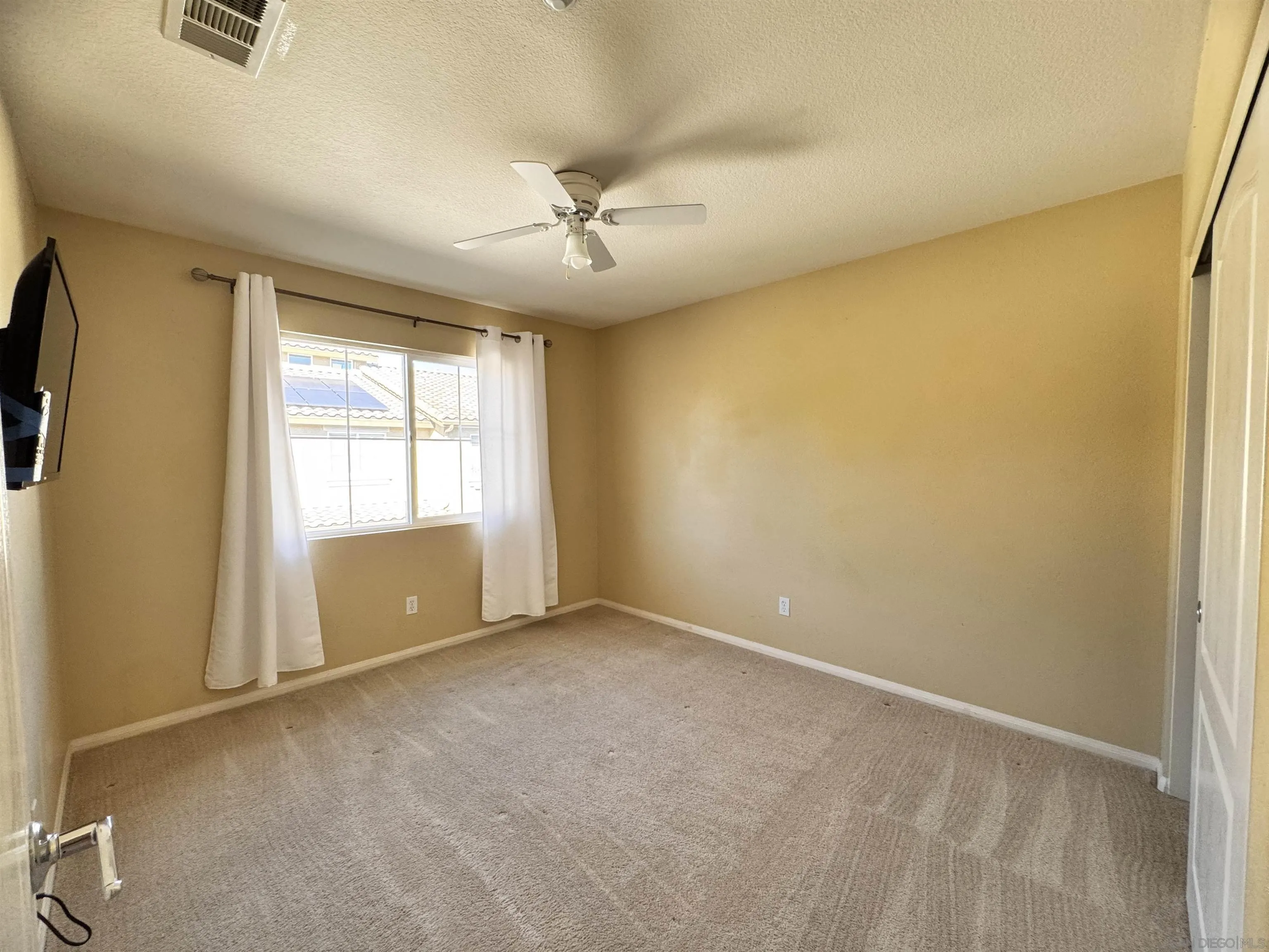 10430 Shelborne Street, Unit 37 San Diego, CA 92127 - Photo 27 of 27 an empty room with windows and chandelier fan