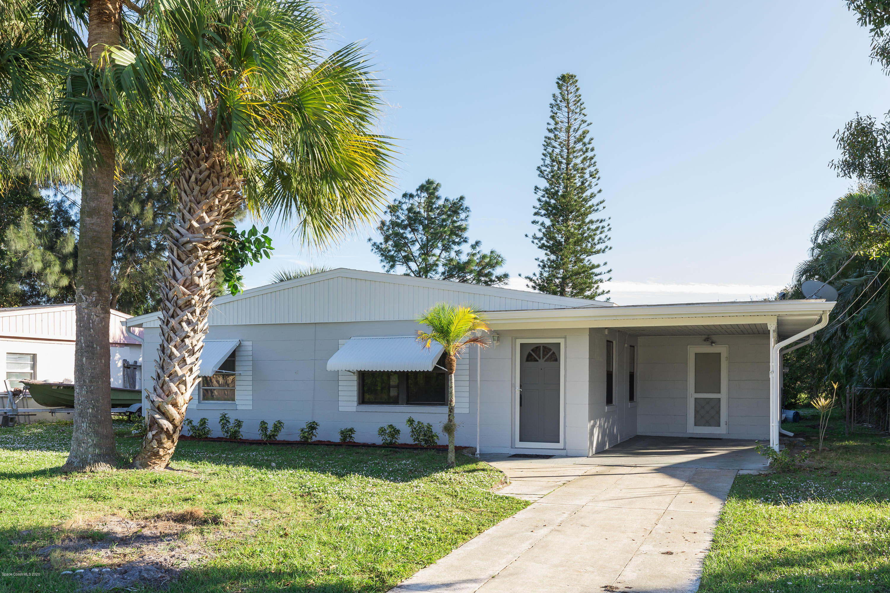 115 Cherry Street Melbourne, FL 32901 - Photo 1 of 12 a front view of a house with a yard and garage