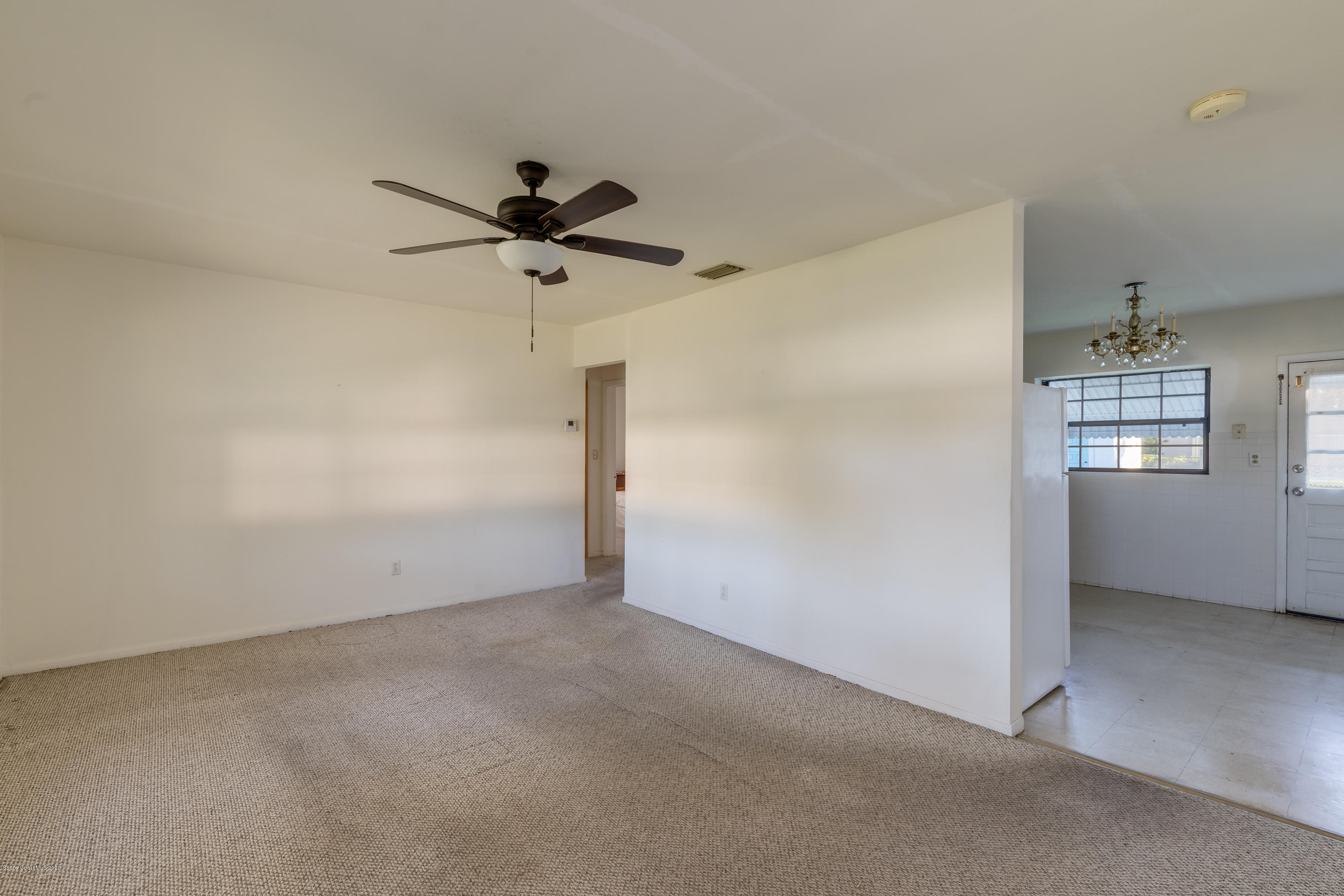 115 Cherry Street Melbourne, FL 32901 - Photo 3 of 12 a view of a room with a ceiling fan and carpet