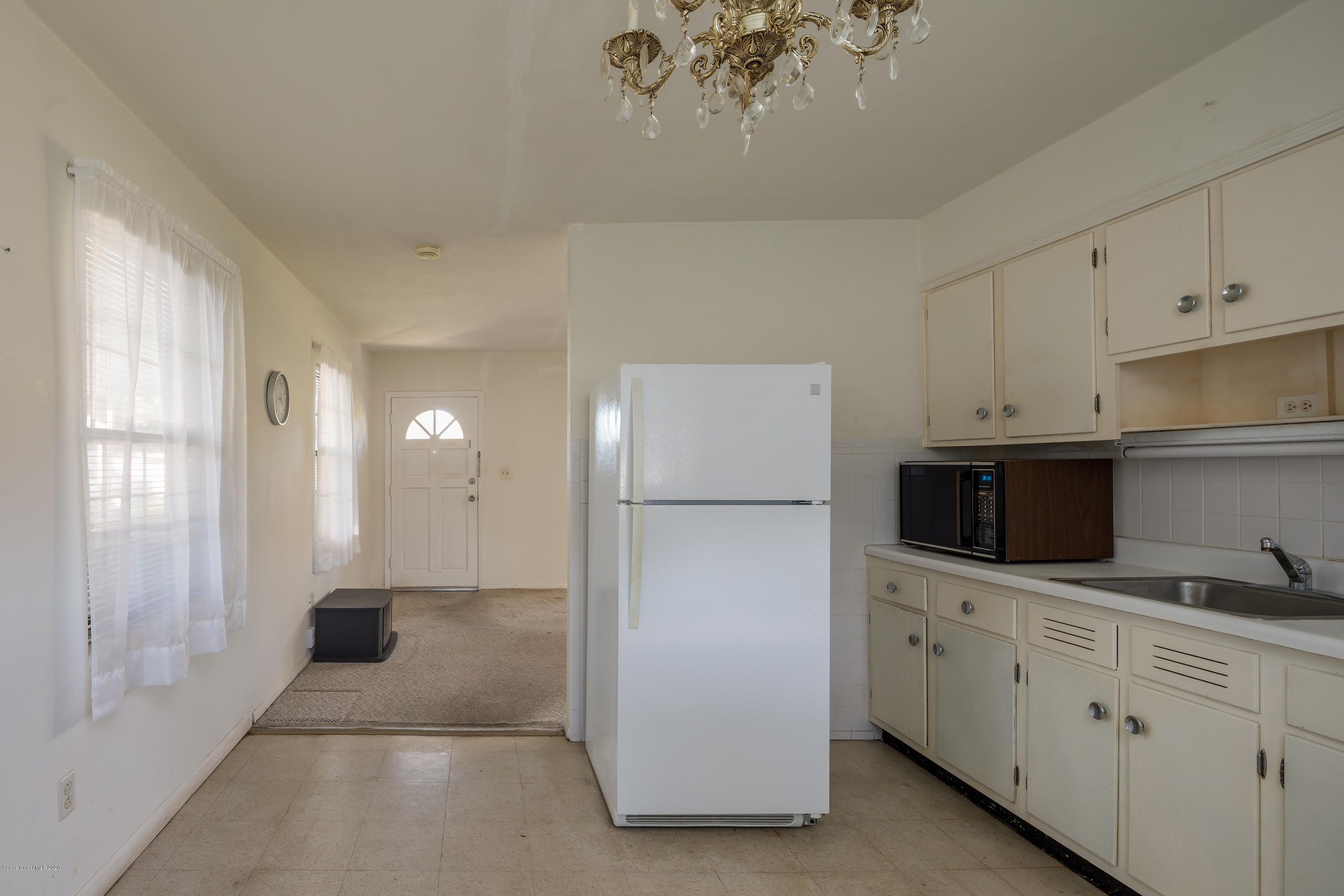115 Cherry Street Melbourne, FL 32901 - Photo 6 of 12 a kitchen with white cabinets and white appliances