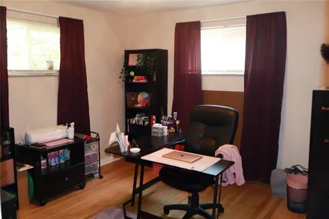 a work room with furniture a bookshelf and a window