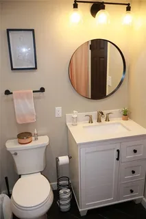 a bathroom with a toilet a sink and mirror