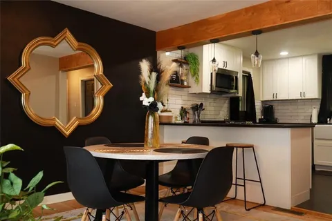 a kitchen with a table chairs and a wooden floor