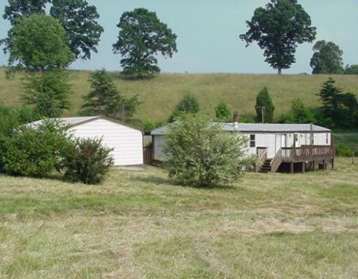 a view of a house with a yard and lake view