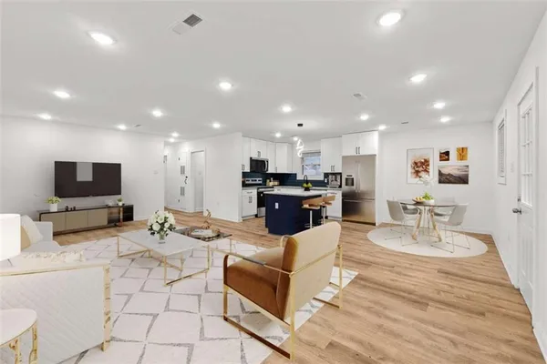 a living room with furniture kitchen view and a flat screen tv