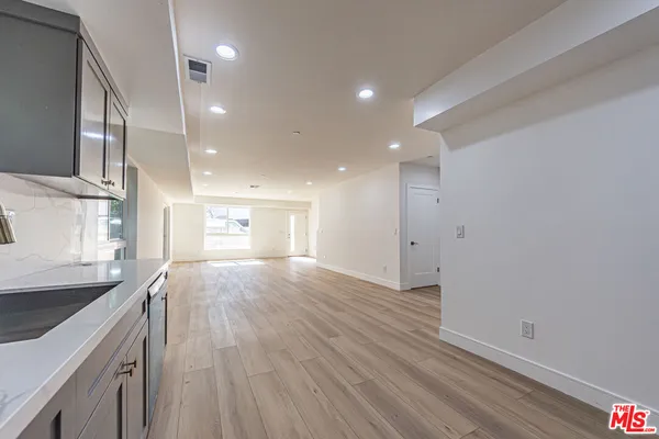 a view of a kitchen with a sink and wooden floor