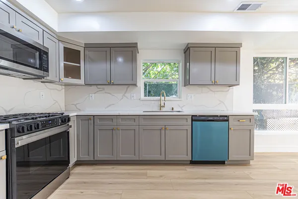 a kitchen with stainless steel appliances granite countertop a sink stove and microwave