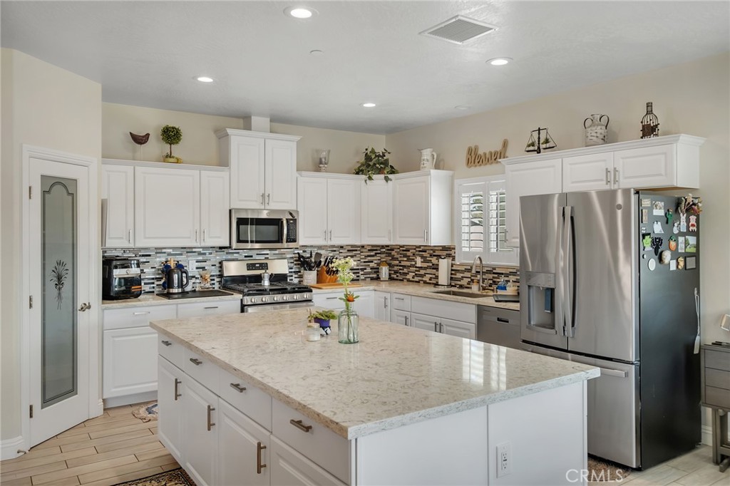 13178 Setancket Road Apple Valley, CA 92308 - Photo 9 of 24 a kitchen with refrigerator a stove and cabinets