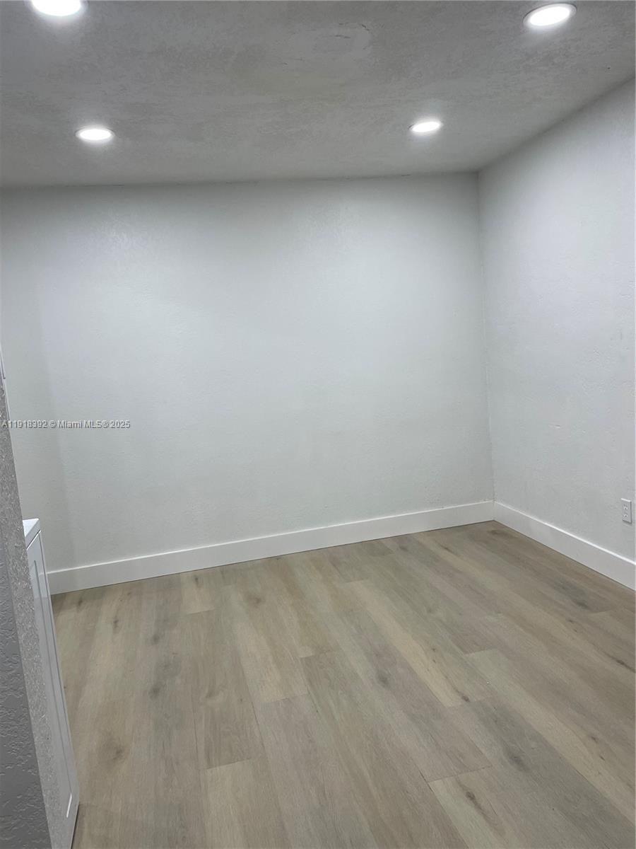 5261 Northwest 1st Street, Unit FRONT Miami, FL 33126 - Photo 14 of 14 an empty room with wooden floor and windows