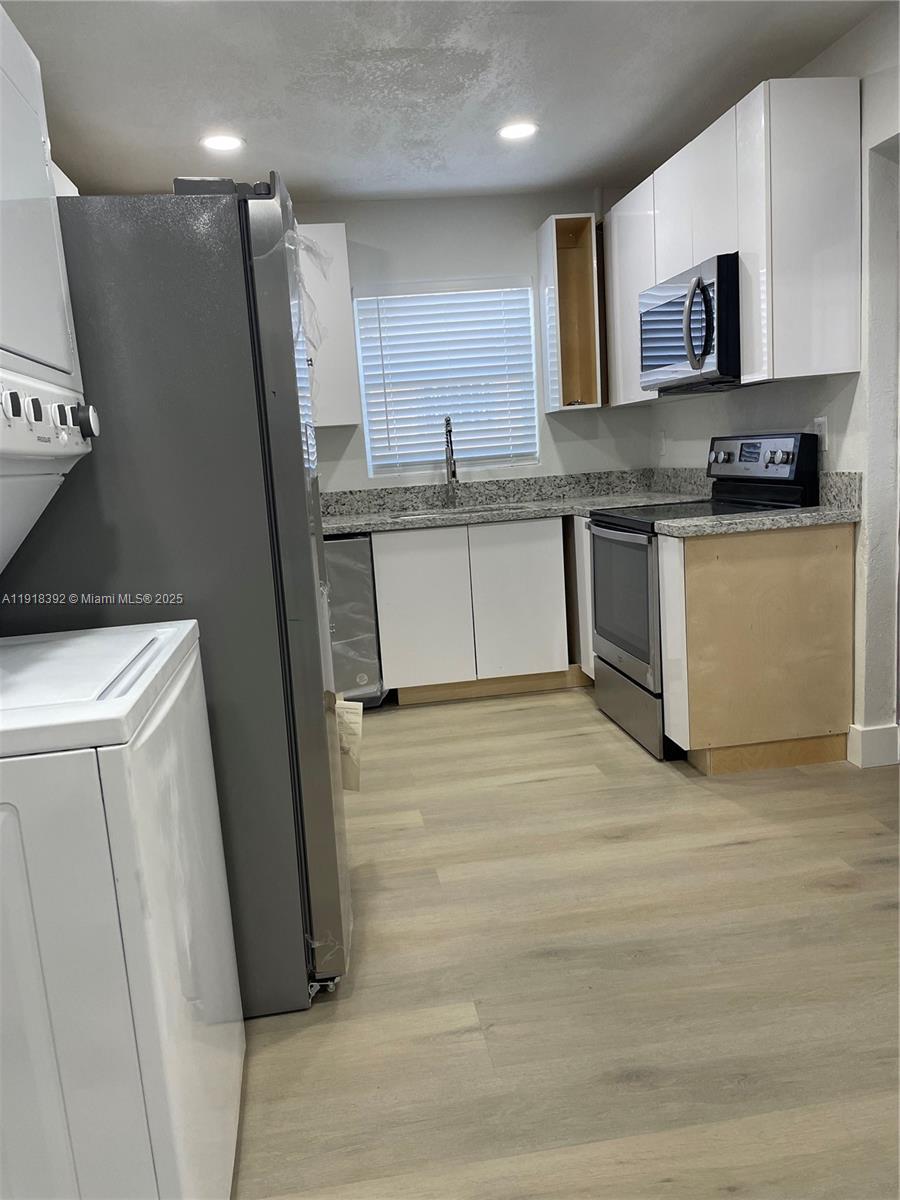 5261 Northwest 1st Street, Unit FRONT Miami, FL 33126 - Photo 5 of 14 a kitchen with stainless steel appliances granite countertop a refrigerator and a stove top oven