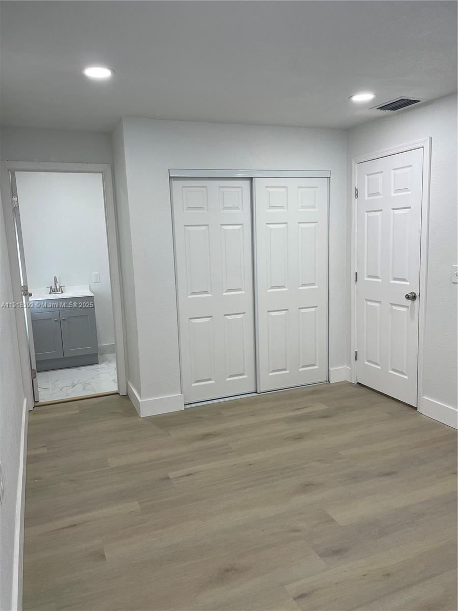 5261 Northwest 1st Street, Unit FRONT Miami, FL 33126 - Photo 6 of 14 an empty room with cabinet and mirrors