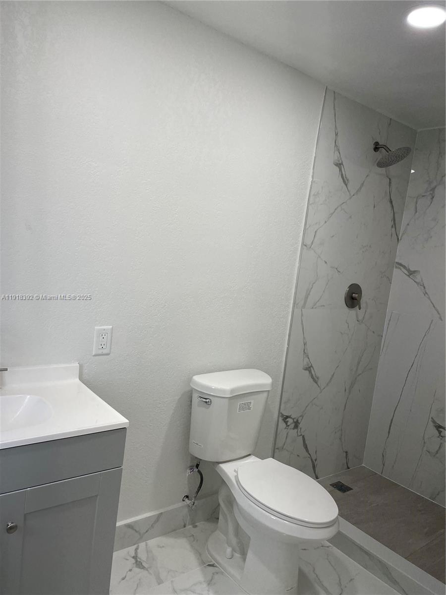 5261 Northwest 1st Street, Unit FRONT Miami, FL 33126 - Photo 7 of 14 a white toilet sitting next to a bathroom sink