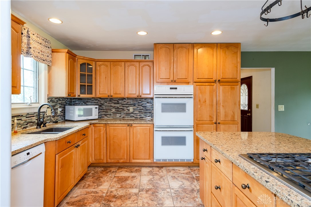 9981 Ridge Acres Lane Englewood, OH 45322 - Photo 14 of 73 This spacious kitchen offers ample storage, expansive countertops, and a functional island with a gas cooktop.