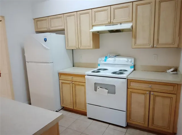 a kitchen with a refrigerator sink and cabinets