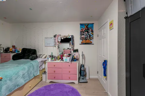 a bedroom with a bed and a refrigerator