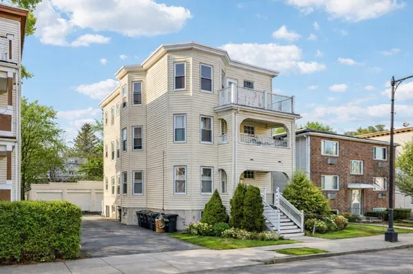 a front view of a residential apartment building with a yard
