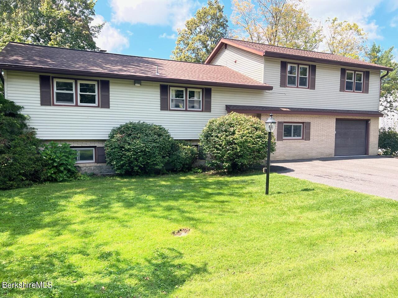 72 Brunell Avenue Lenox, MA 01240 - Photo 1 of 27 a house that has a big yard and large trees
