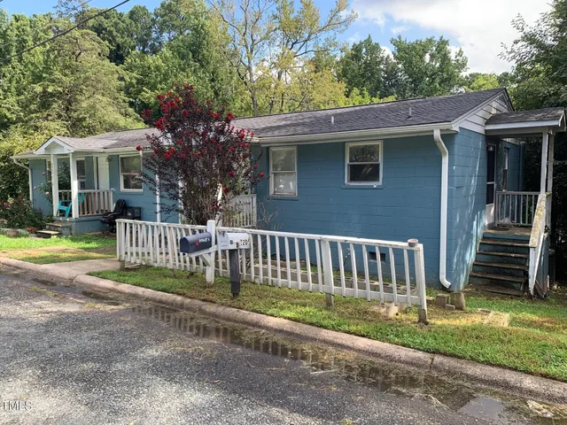 a view of a house with a yard and fence