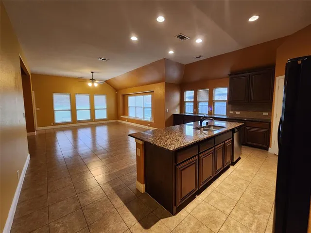 a kitchen with stainless steel appliances granite countertop a stove and a refrigerator