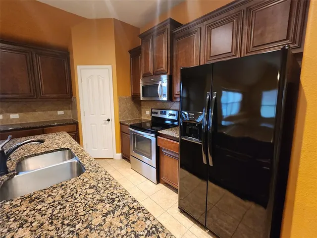 a kitchen with a refrigerator stove and cabinets