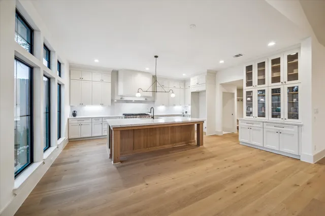 a large kitchen with kitchen island a sink stainless steel appliances and cabinets