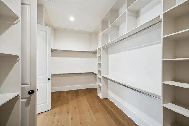 a view of walk in closet with wooden floor