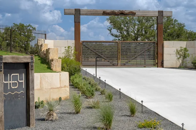 a view of a brick house with a small yard and potted plants